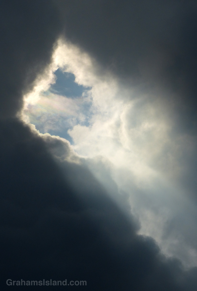 The sun shines through a hole in the clouds