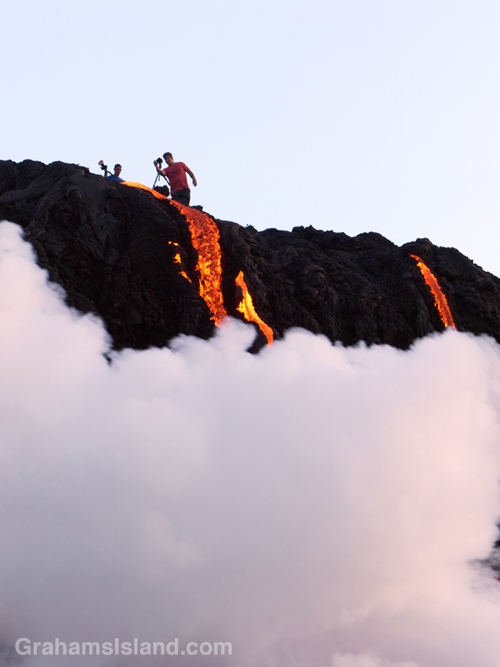 A photographer gets close to the flow as Kilauea lava reaches the ocean.
