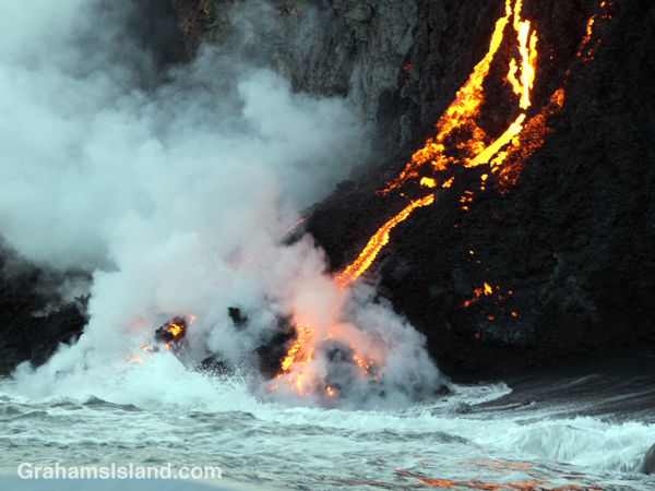 Kilauea lava reaches the ocean with a surge of steam.