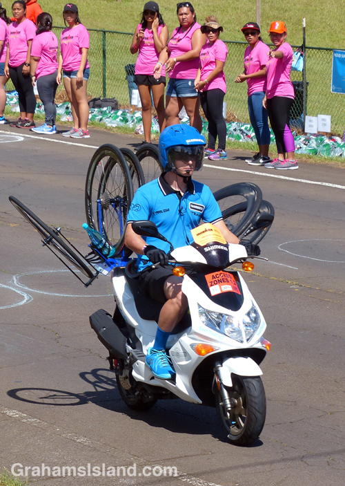 A support person carries spare wheels at the IRONMAN world championship on the Big Island. 