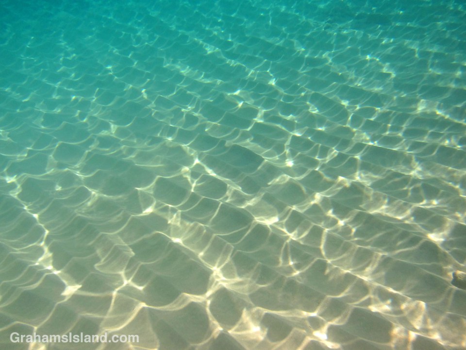 Usually waves are seen on the water, but here at Waialea, the waves are light and sand below the water.
