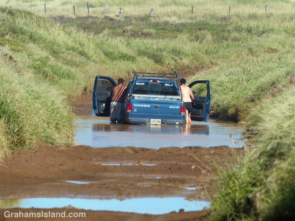 A truck stuck in a muddy puddle on the Big Island of Hawaii