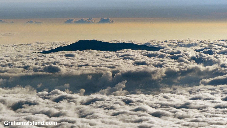 The top of Hualalai Volcano pokes through the clouds on the Big Island of Hawaii.