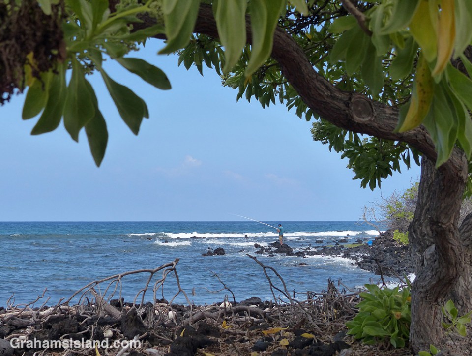 A man tries his luck fishing on the shore of Kaloko-Honokohau National Historical Park north of Kailua Kona.