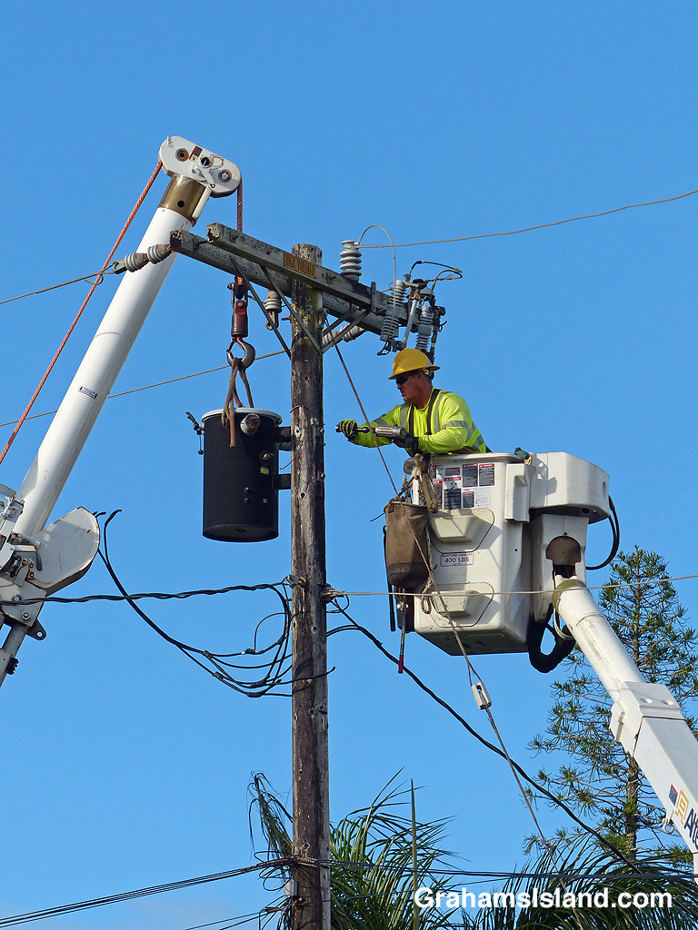 Workers prepare to remove and electrical transformer
