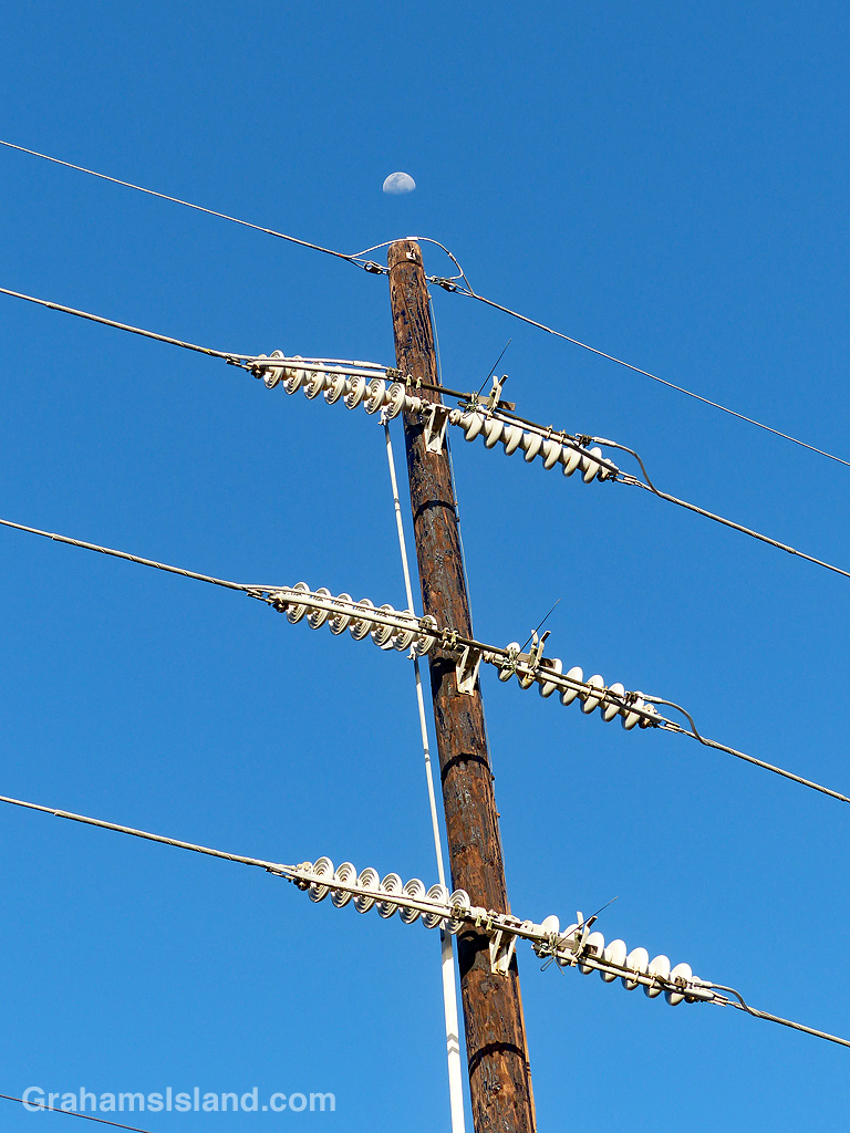 The moon seen above a power pole