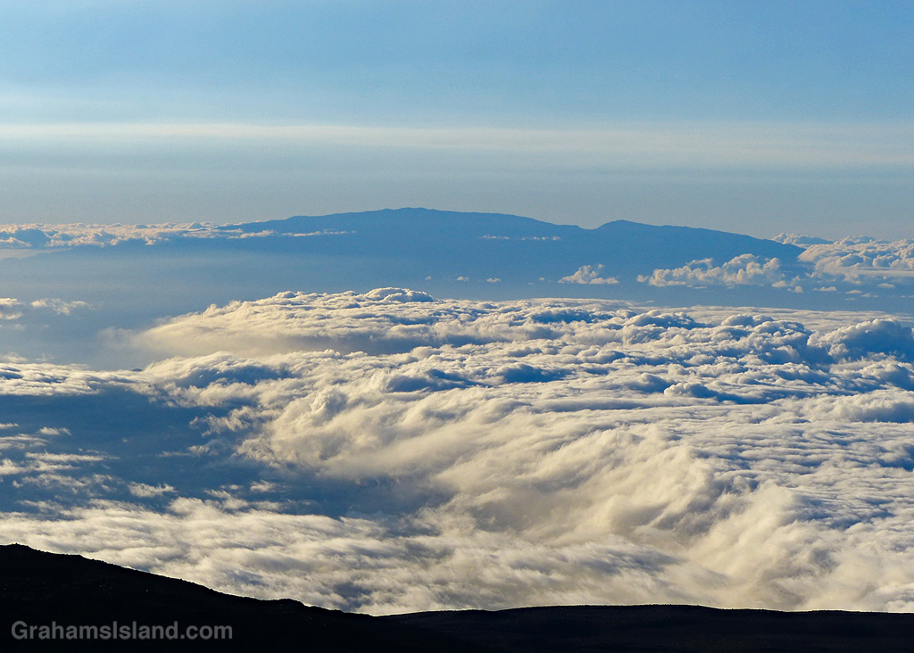 Clouds fill the sky between Mauna Kea and Maui