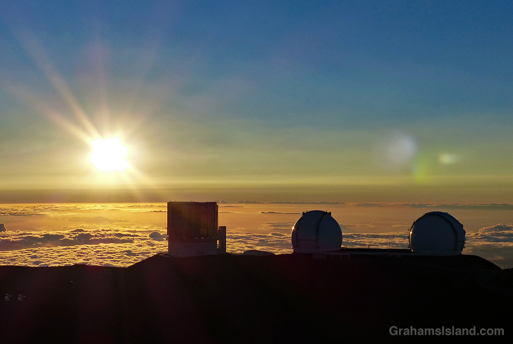 Three telescopes on the summit of Mauna Kea at sunset