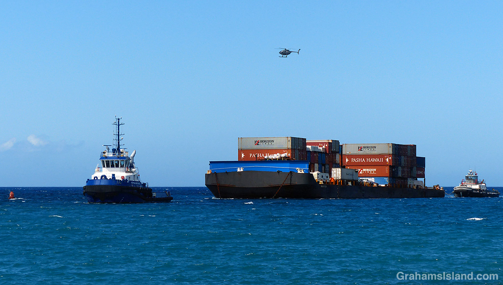 A tug and barge enters Kawaihae Harbor in Hawaii