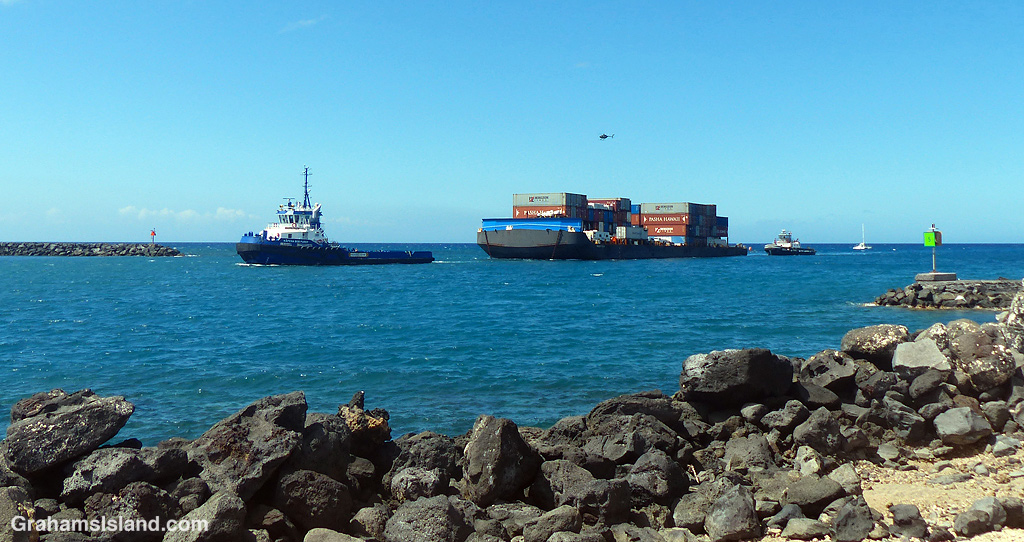 A tug and barge enters Kawaihae Harbor in Hawaii
