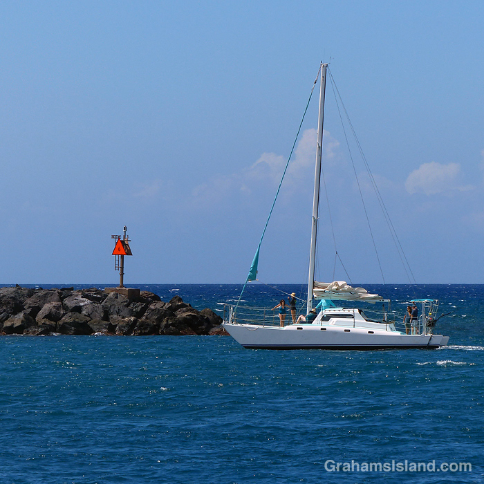 A sailboat enters Kawaihae Harbor