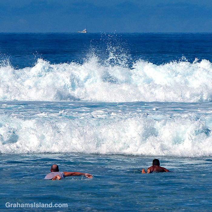 Surfers heads out at Pine Trees, Hawaii
