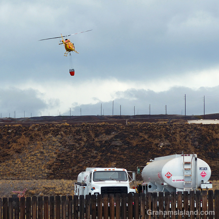 A firefighting helicopter gathers water to fight a brush fire in Hawaii
