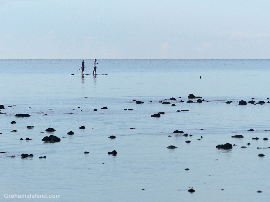 Paddleboarders cross the bay at Kawaihae on a calm morning