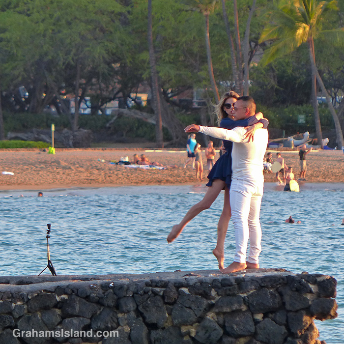 A couple performs on the beach at sunset in Hawaii
