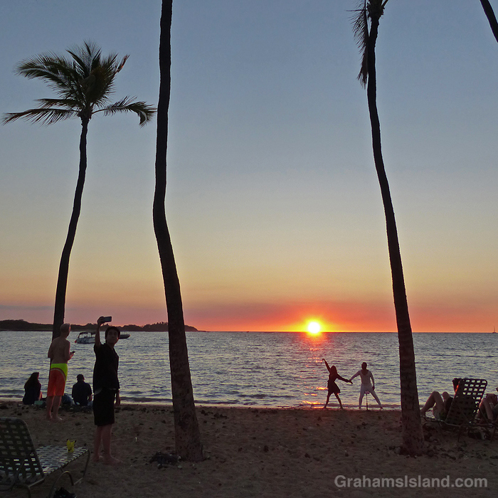 A couple performs on the beach at sunset in Hawaii