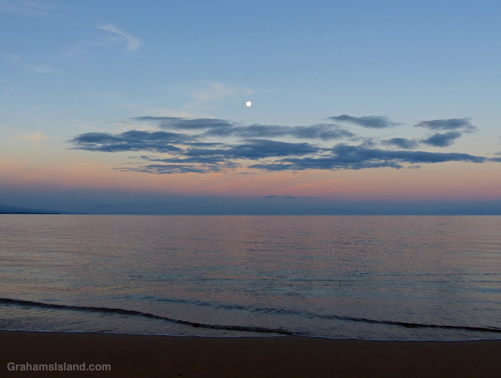 A Full moon hangs over the ocean at Spencer Beach Park in Hawaii