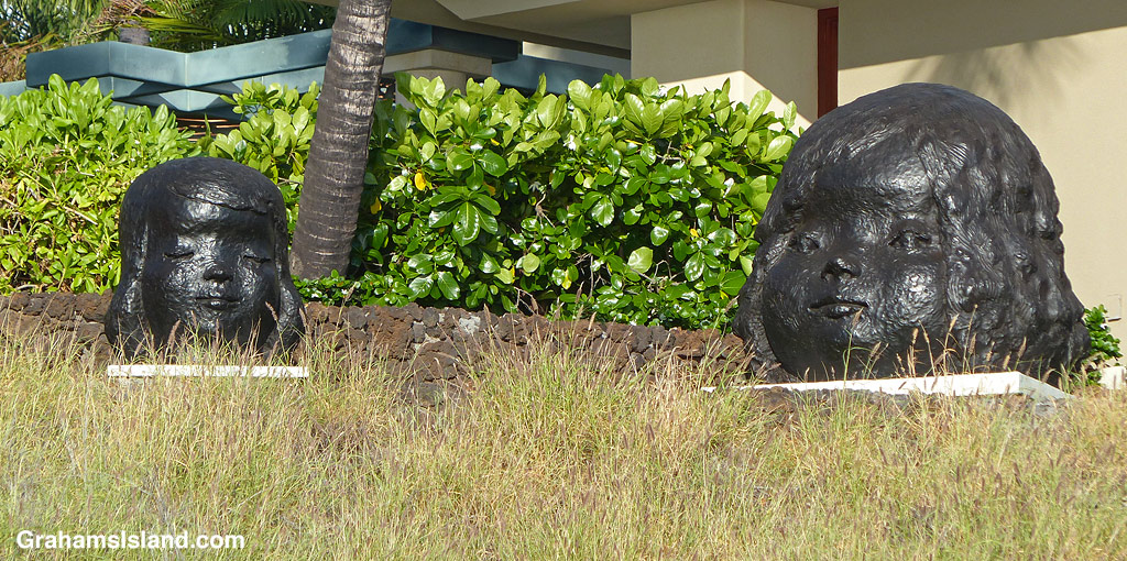 A sculpture of two heads seen from the coast path in front of Mauna Kea Resort in Hawaii