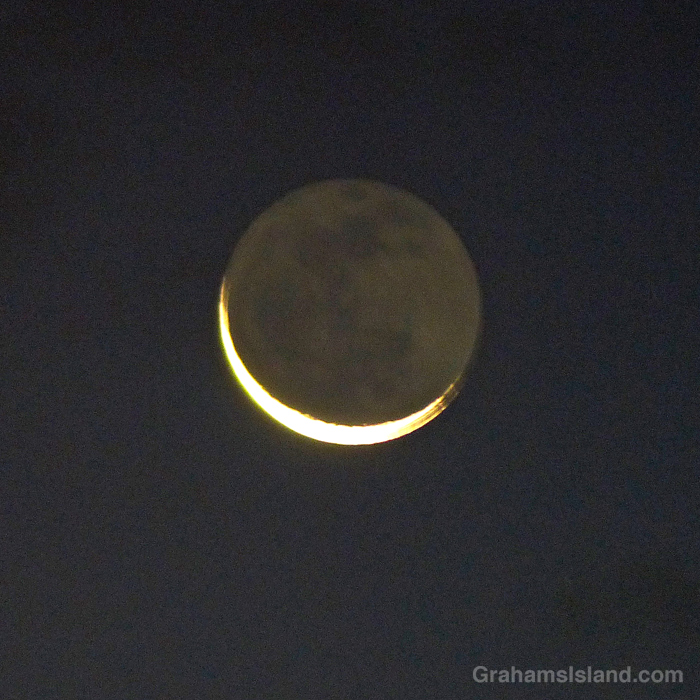 A sliver of moon rises over Mauna Kea, Hawaii