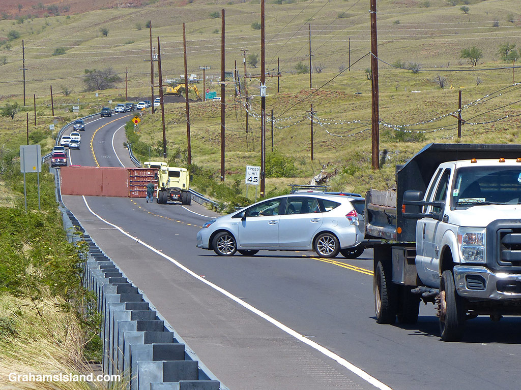 A semi-truck trailer is blown over on a highway in Hawaii