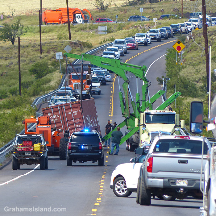 A semi-truck trailer, blown over on a highway in Hawaii, is recovered