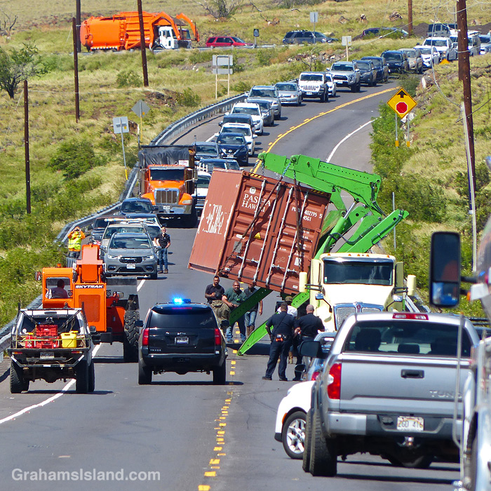 A semi-truck trailer, blown over on a highway in Hawaii, is recovered