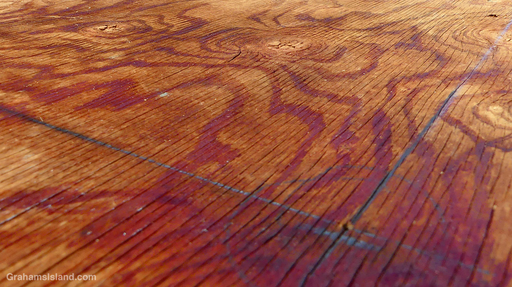 A plywood floor with red marks on it
