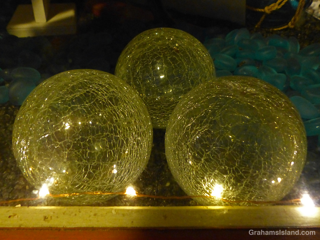 Three illuminated balls in a window display in Hawaii