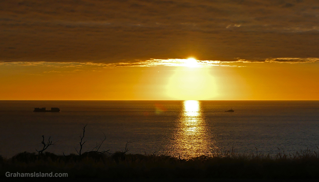 A tug and barge off the Kohala coast shortly before sunset