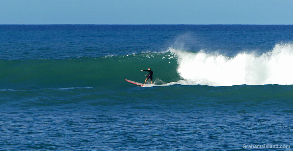 A Surfer catches a wave at Kawaihae, Hawaii