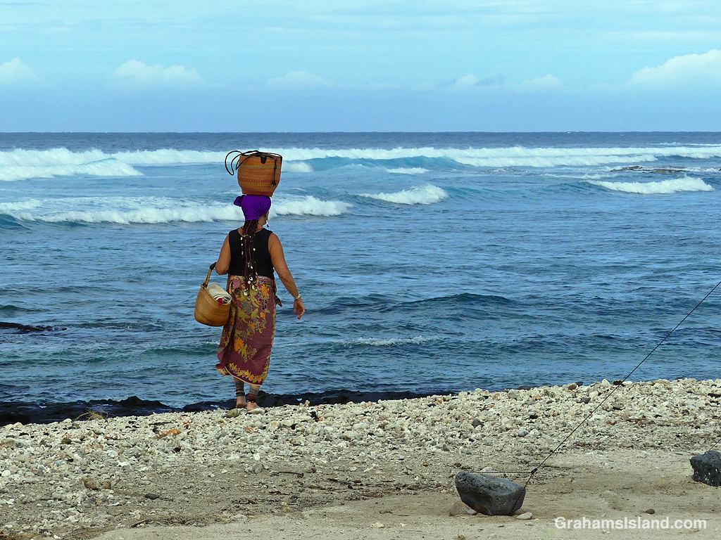 A woman walks on the beach at Kohanaiki Park in Hawaii