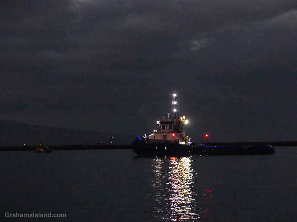A tug and barge enter Kawaihae Harbor in the early morning