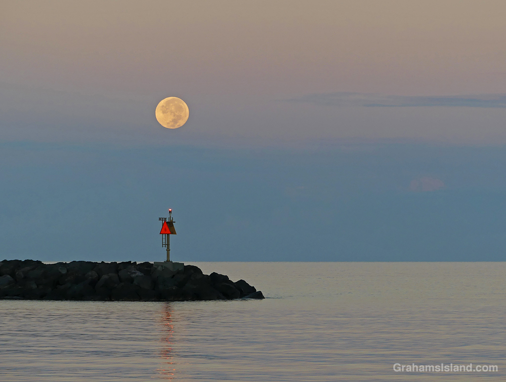 A full moon sets from Kawaihae Hawaii