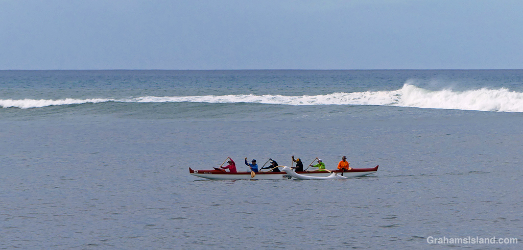Canoe paddlers head towards the shore off the coast of Hawaii