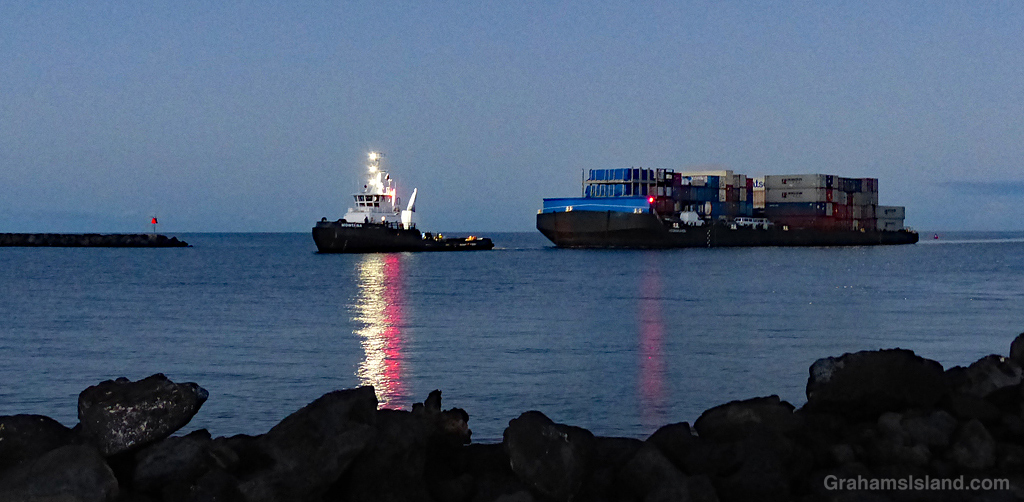 A tug and barge enter Kawaihae Harbor in Hawaii