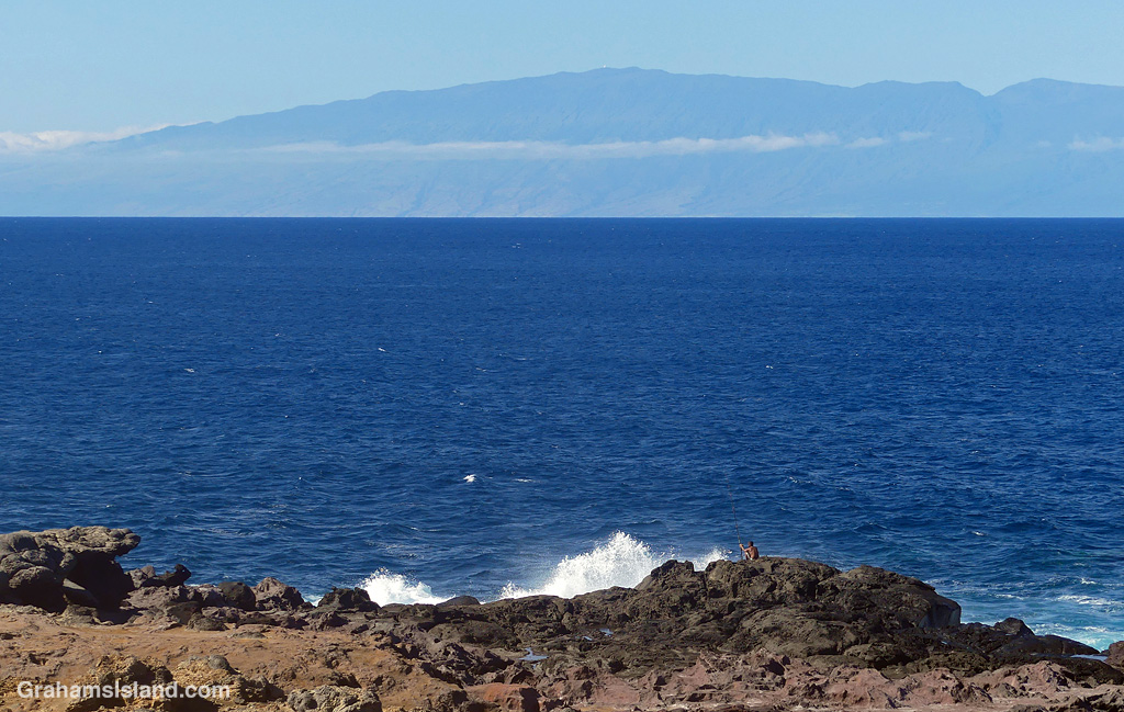 A fisherman at Upolu with Maui in the background