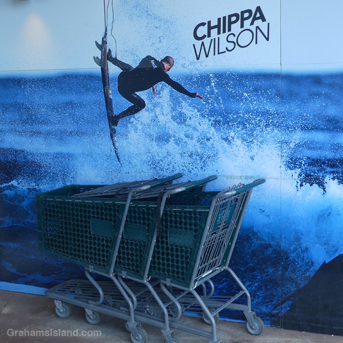 A poster of surfer Chippa Wilson behind shopping trolleys in Hawaii