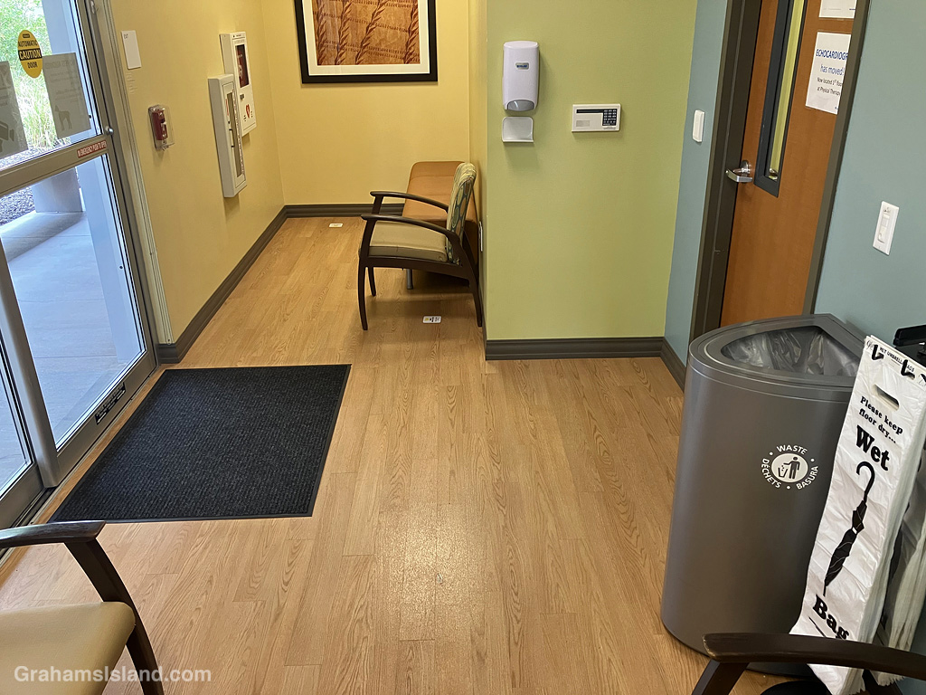 A waiting room, with a wet bag depository across the room from the door