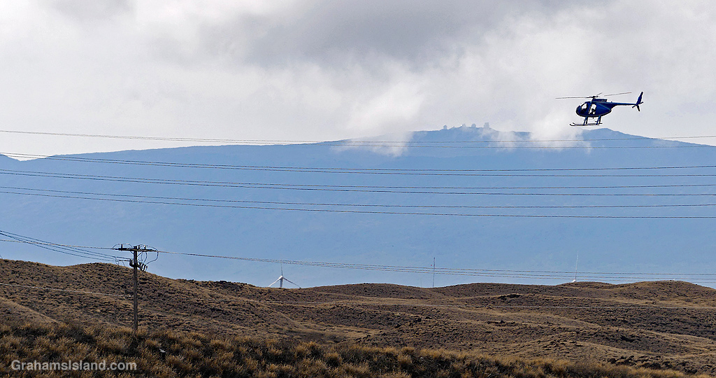 A helicopter flies over power lines in Hawaii