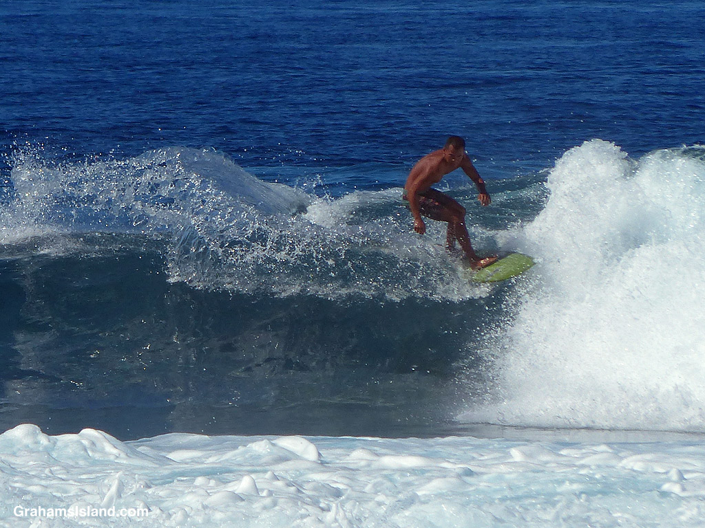 A surfer rides a wave in Hawaii