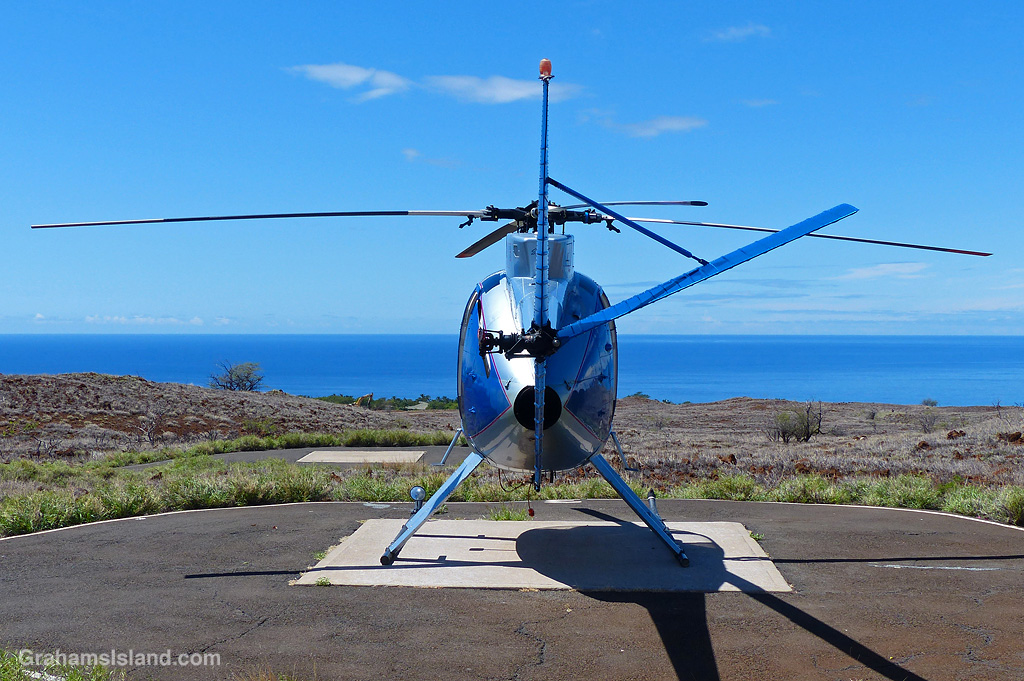 A small Blue helicopter waits on a helipad at Hapuna, Hawaii