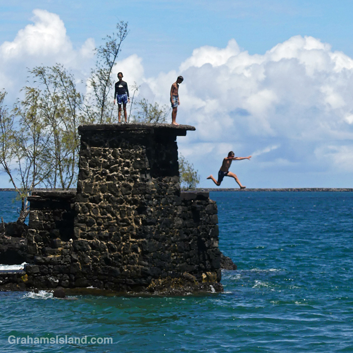 Kids jump into the water at Coconut Island in Hilo, Hawaii