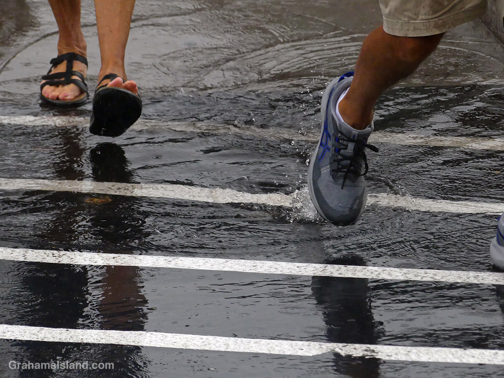Feet splashing through rain puddles in Kailua Kona, Hawaii